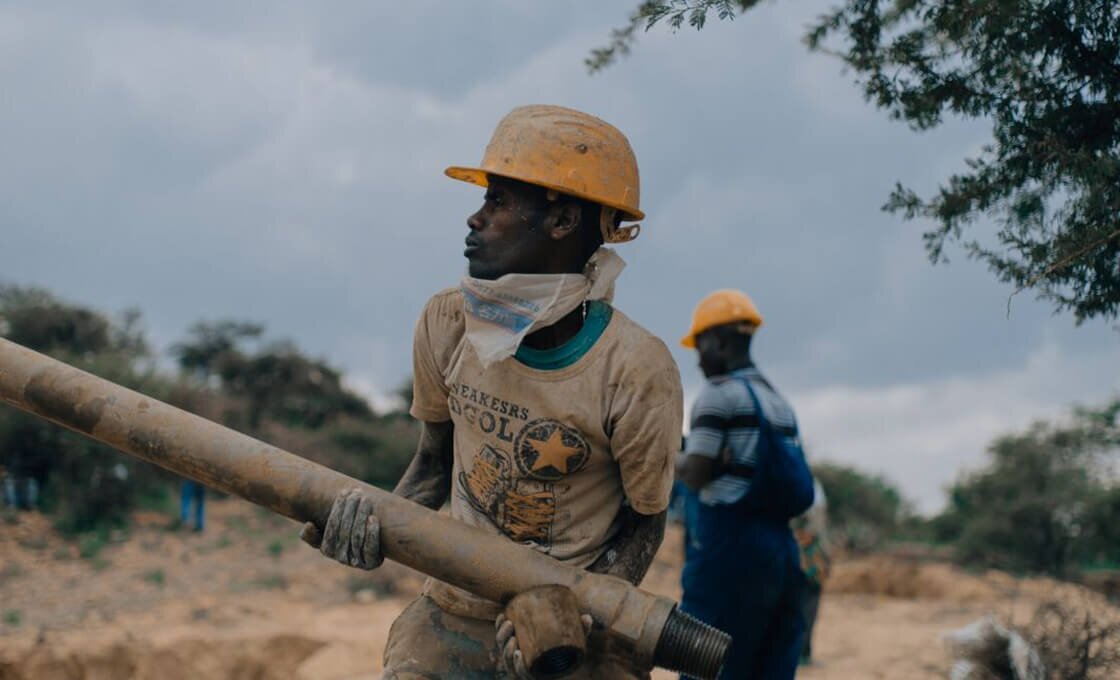 African man building a water access point