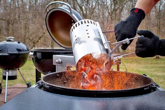Dumping hot coals into grill
