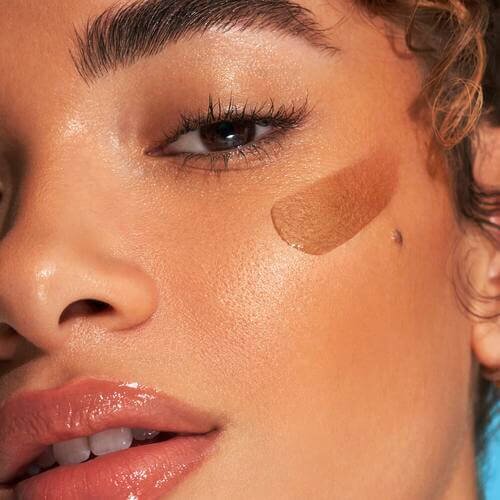 Model applying e.l.f. SKIN bronzing drops