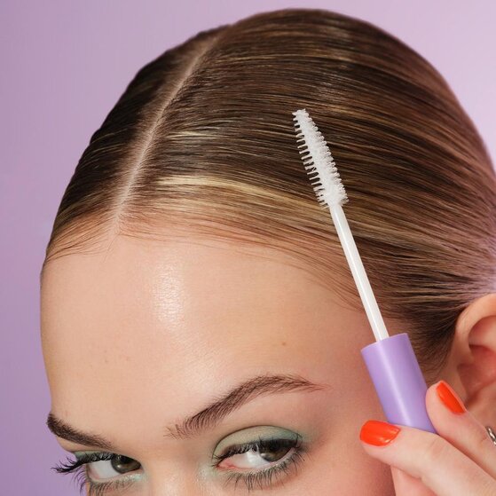 model taming flyaways with styling cream wand