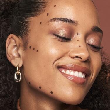 Model with oval face shape showing a face map of where to apply liquid bronzer