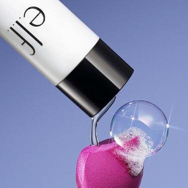 e.l.f. makeup cleanser is being poured on the makeup sponge