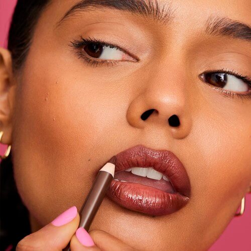 Woman applying brown lip liner