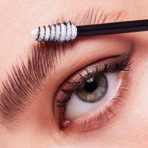 Woman applying laminating brow gel to her eyebrow