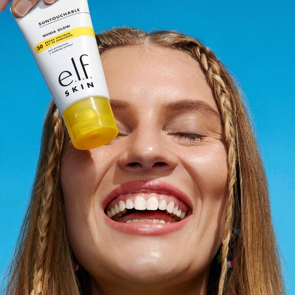 Woman holding Suntouchable Whoa Glow SPF 30