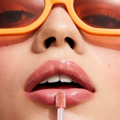 Someone applying e.l.f. Sun Boss Gloss SPF 25 on their lip.