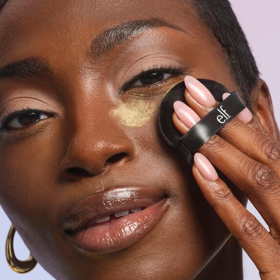 model using powder puff to apply loose powder