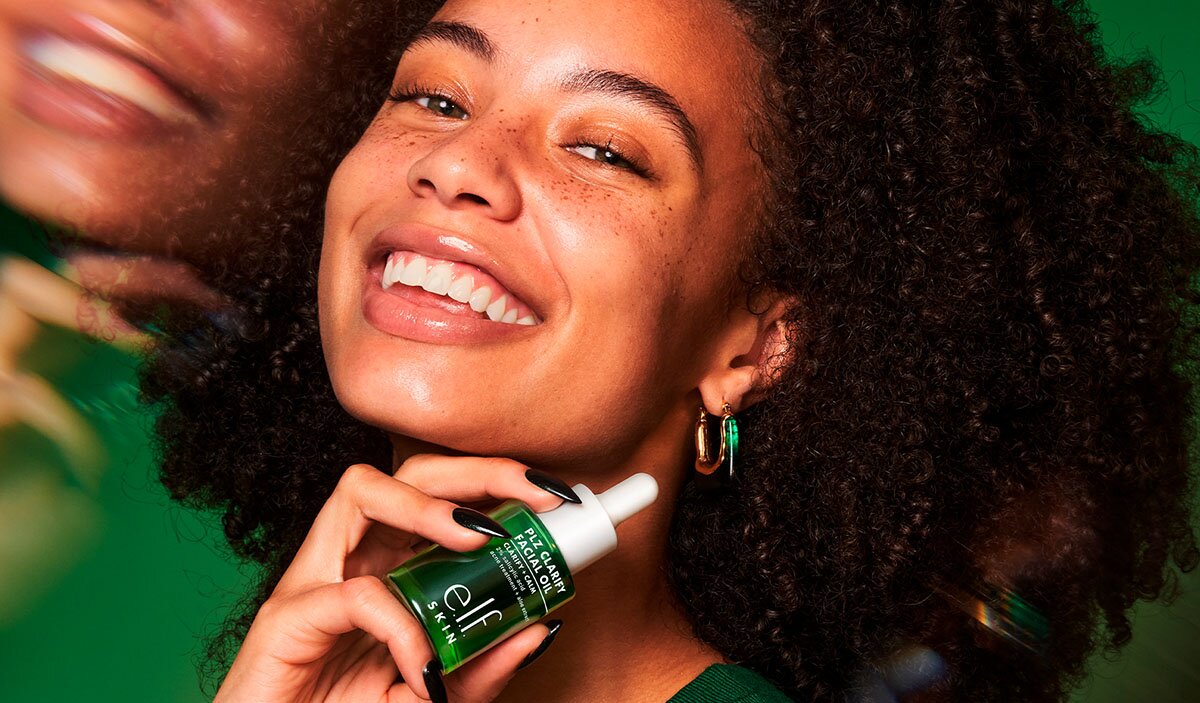 Model holding e.l.f. SKIN clarifying facial oil