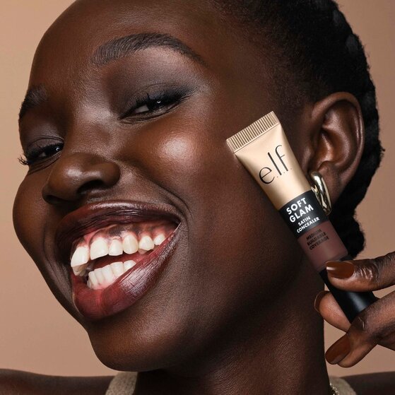 Model holding soft glam satin concealer