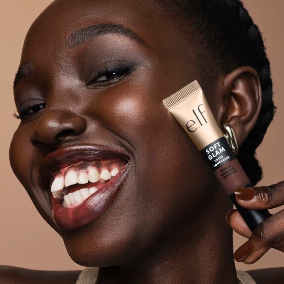 Model holding soft glam satin concealer