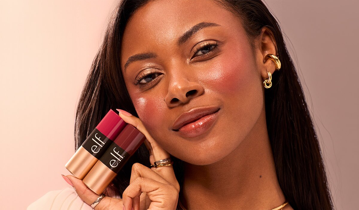 Model holding cream blush sticks