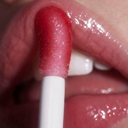 Model applying e.l.f. Glow Reviver Lip Oil on lips
