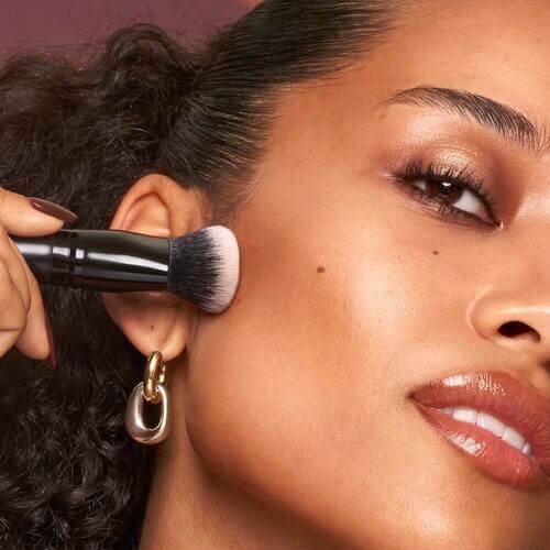 model applying liquid contour with a makeup brush