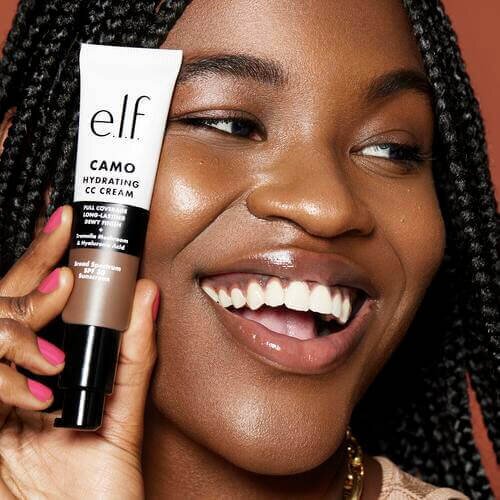 Woman holding Camo Hydrating CC Cream, aka Color-Correcting Cream