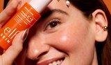 Model holding e.l.f. SKIN vitamin c serum