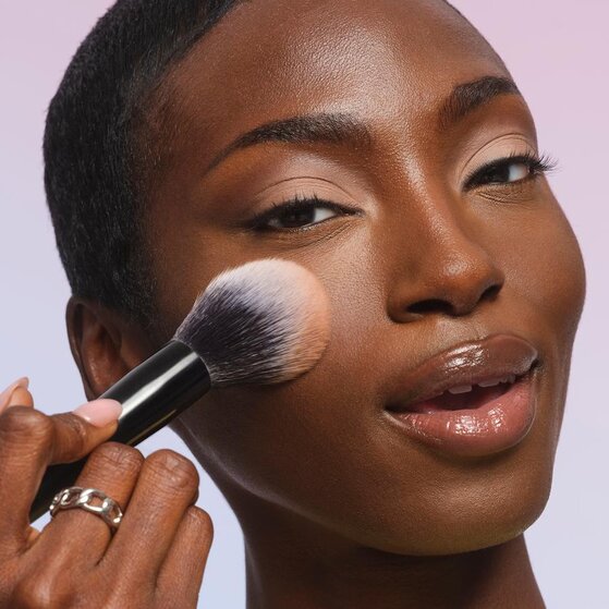Model applying color correcting face powder