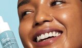 Smiling woman holding hydrating serum