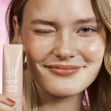Model holding halo glow skin tint with mineral spf 50