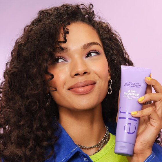 Model with Curly Hair Holding e.l.f.'s 3-in-Wonder Magic Hair Styling Cream