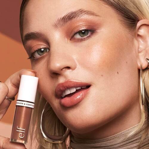 Woman holding and wearing Camo Liquid Bronzer and Contour