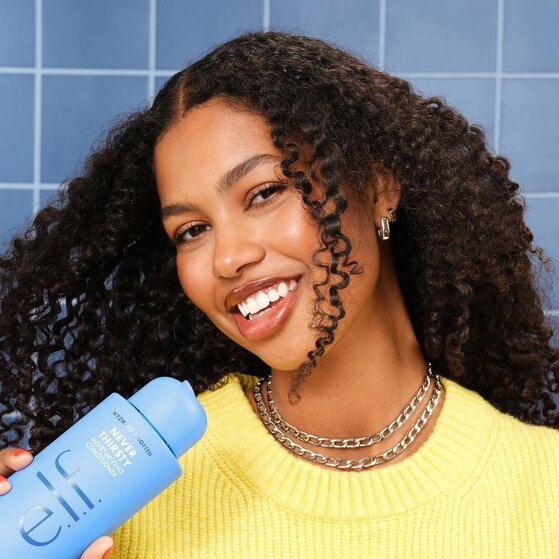 Model with Curly Hair Holding Moisturizing Shampoo