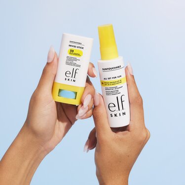 Model holding clear sunscreen stick and sunscreen mist