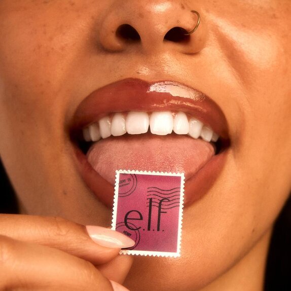 Woman holding up an e.l.f. holiday stamp