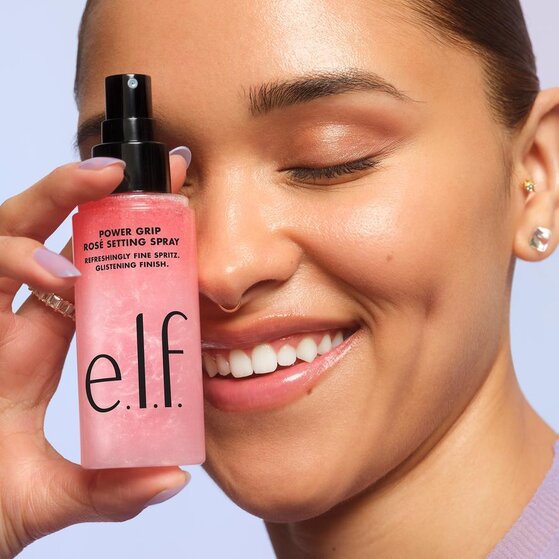 Model prepping her skin for face powder application with setting spray