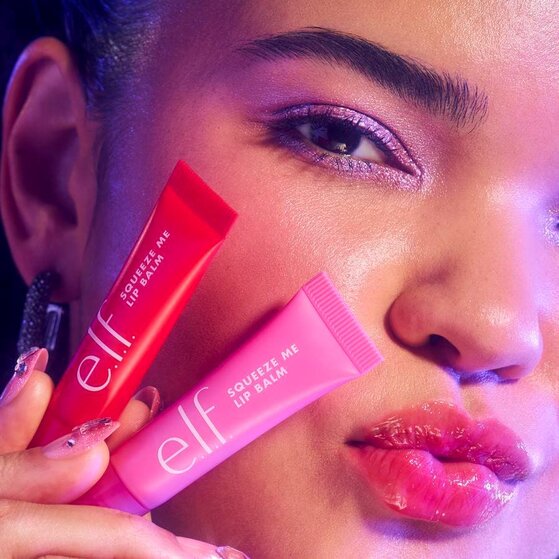 Model holding cherry flavored lip balm and bubblegum flavored lip balm