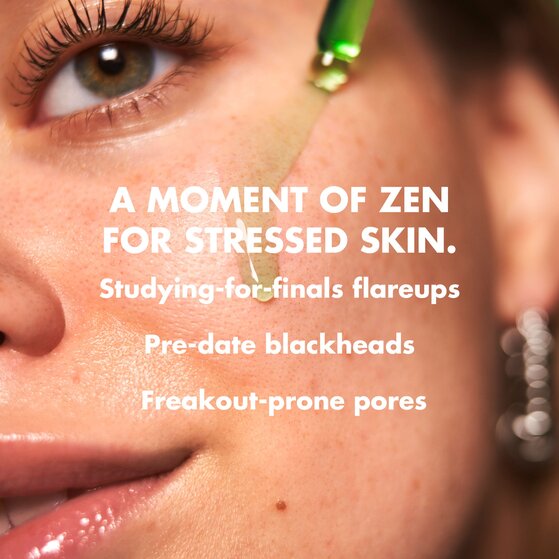 Model applying clarifying facial oil to stressed skin