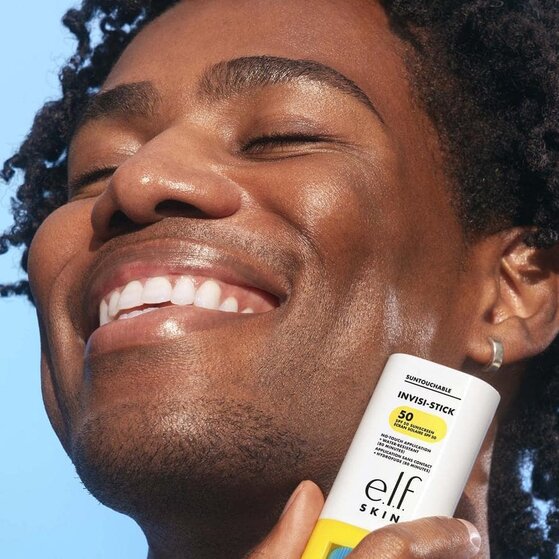 Model applying sunscreen stick to face