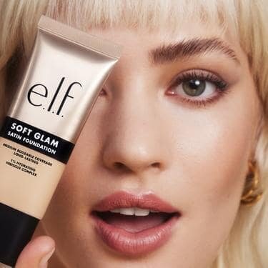 Woman wearing and holding Soft Glam Satin Foundation