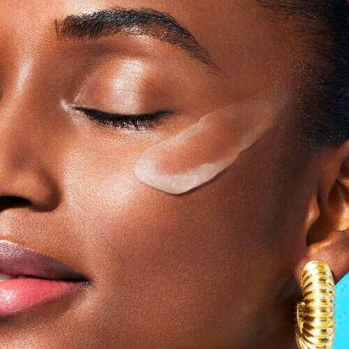 Woman with makeup primer on her cheek