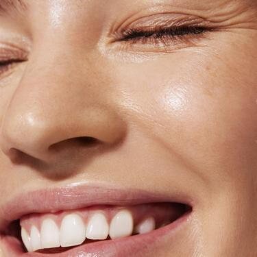 Model smiling showing moisturized skin