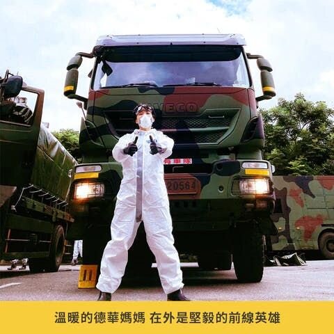 站在軍用車前面穿著防護衣、戴口罩的德華媽媽