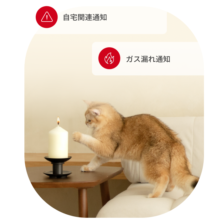 Orange cat reaching toward lit candle on table with 'Home Security Alert' and 'Smoke Alarm Alert' notifications displayed.