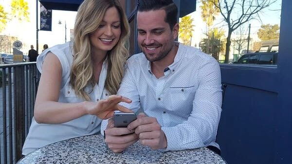 Couple looking at phone, smiling