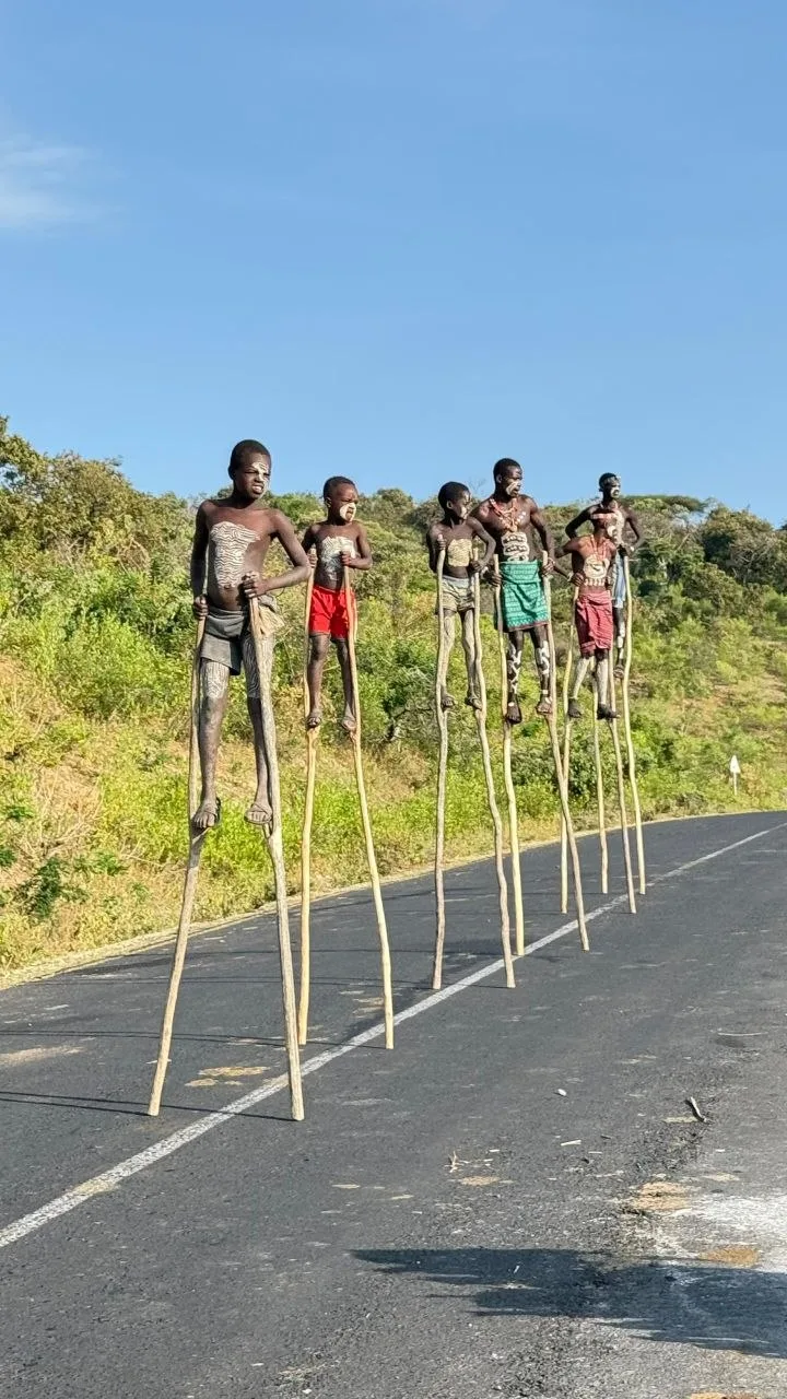 Traditional stilt walkers standing against a blue Ethiopian sky
