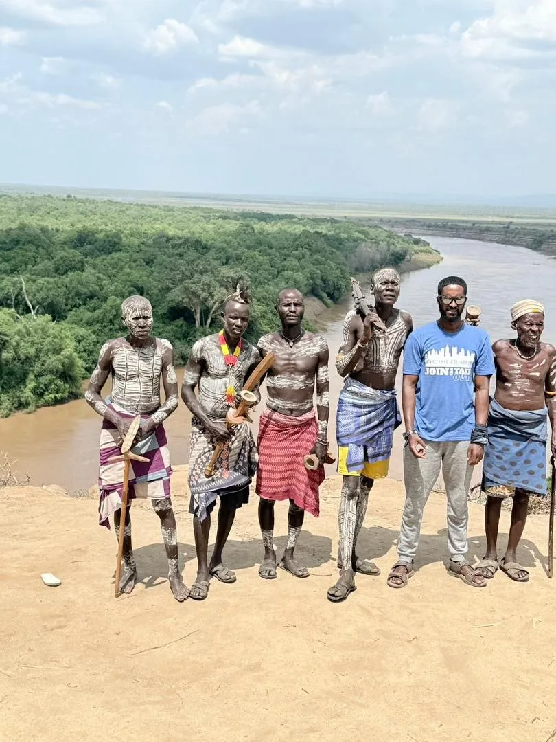 Travelers meeting community members beside a river in Ethiopia