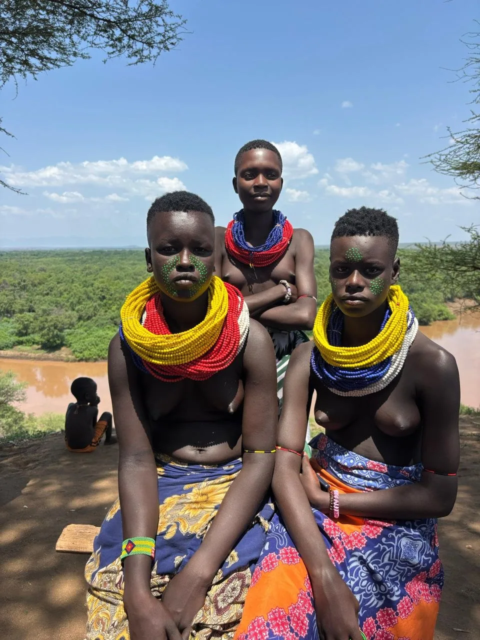 Travelers and a local guide in Ethiopian countryside with mountains behind