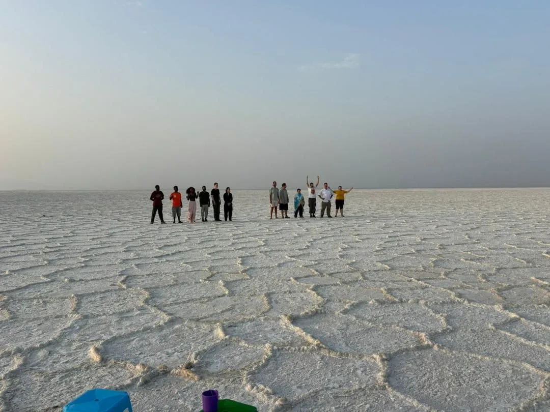 Travelers walking across a white salt landscape in Ethiopia