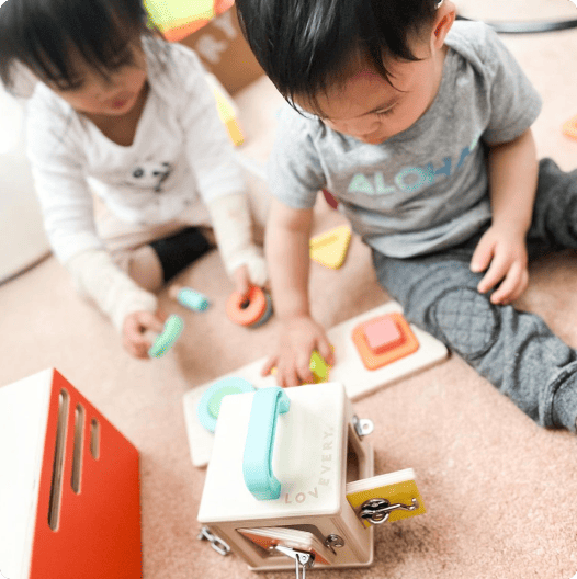 Siblings playing with the Lockbox and Geo Shapes Puzzle