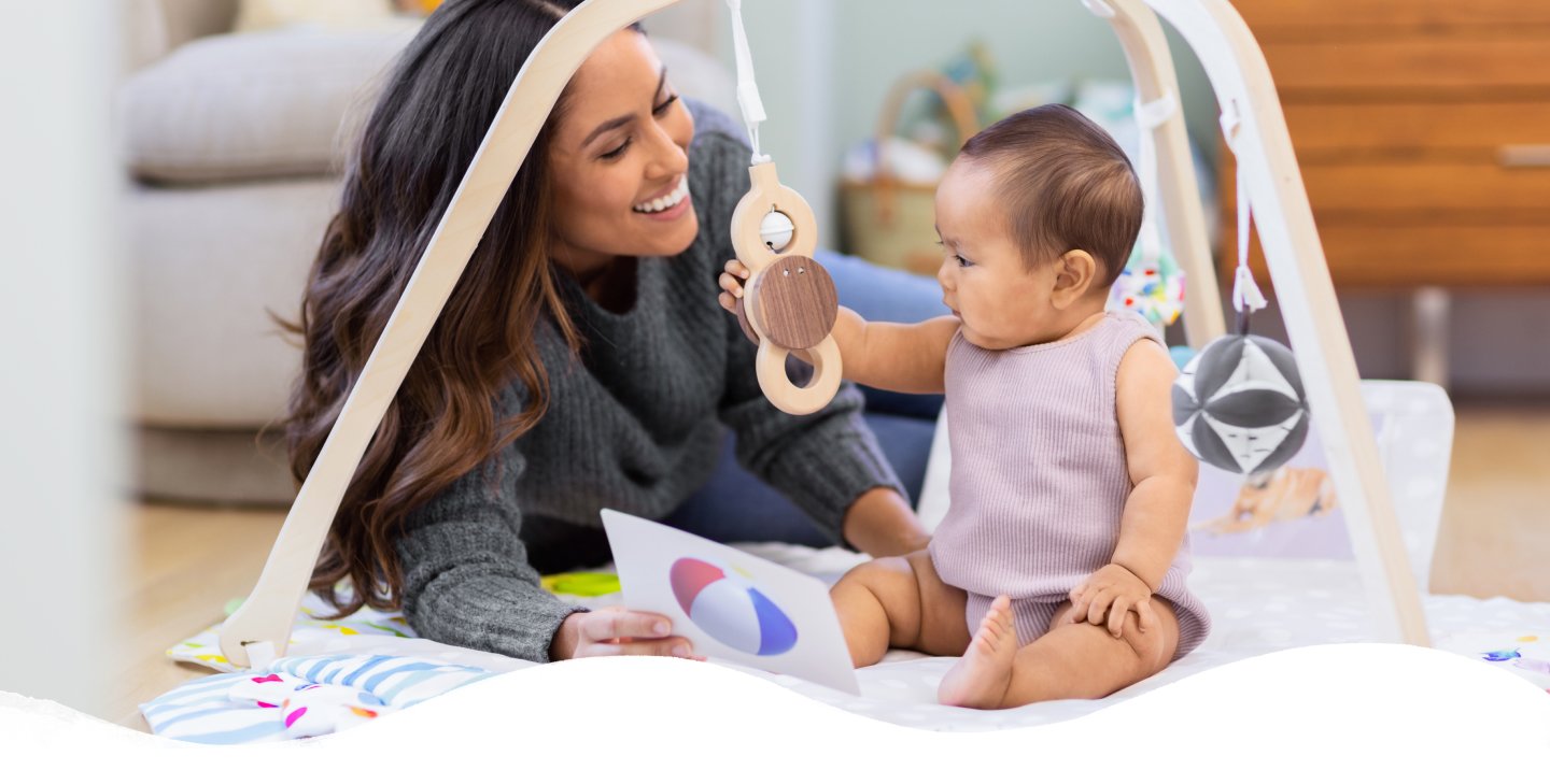 Mother and baby playing with the play gym