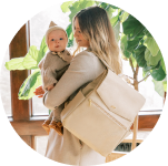 Baby with Béis Travel bagsMother holding baby while wearing the Freshly Picked Diaper Bag II