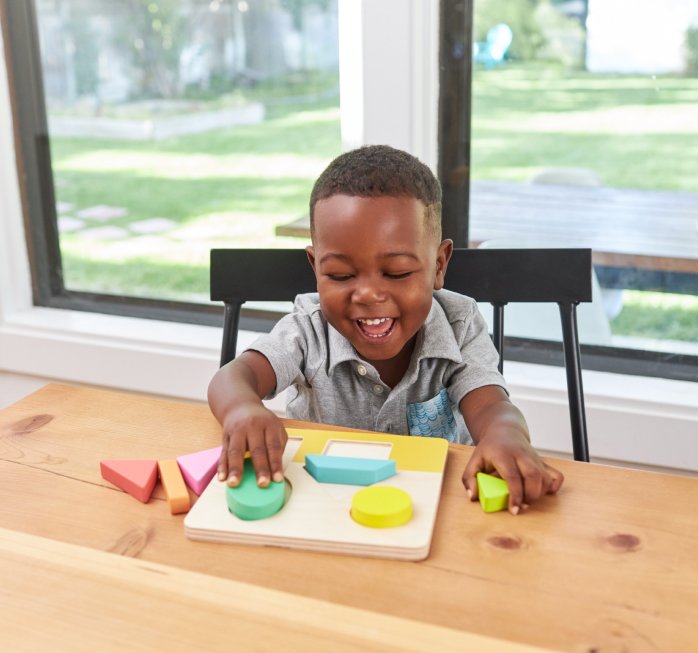 Boy playing with Lovevery puzzle