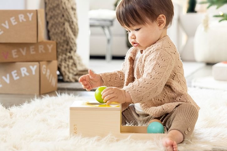 Toddler girl playing with Lovevery toy