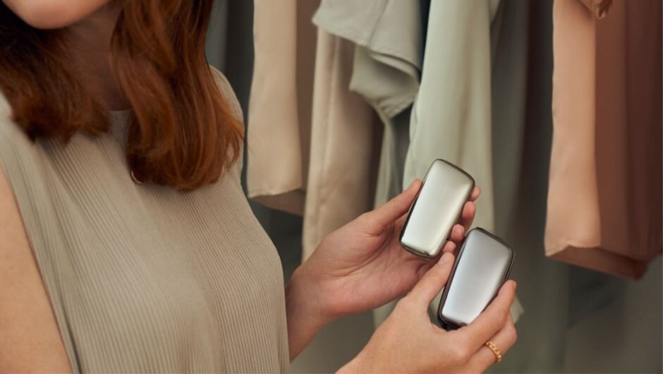 Žena drží v ruke predný kryt a zariadenie Ploom X v striebornej farbe.