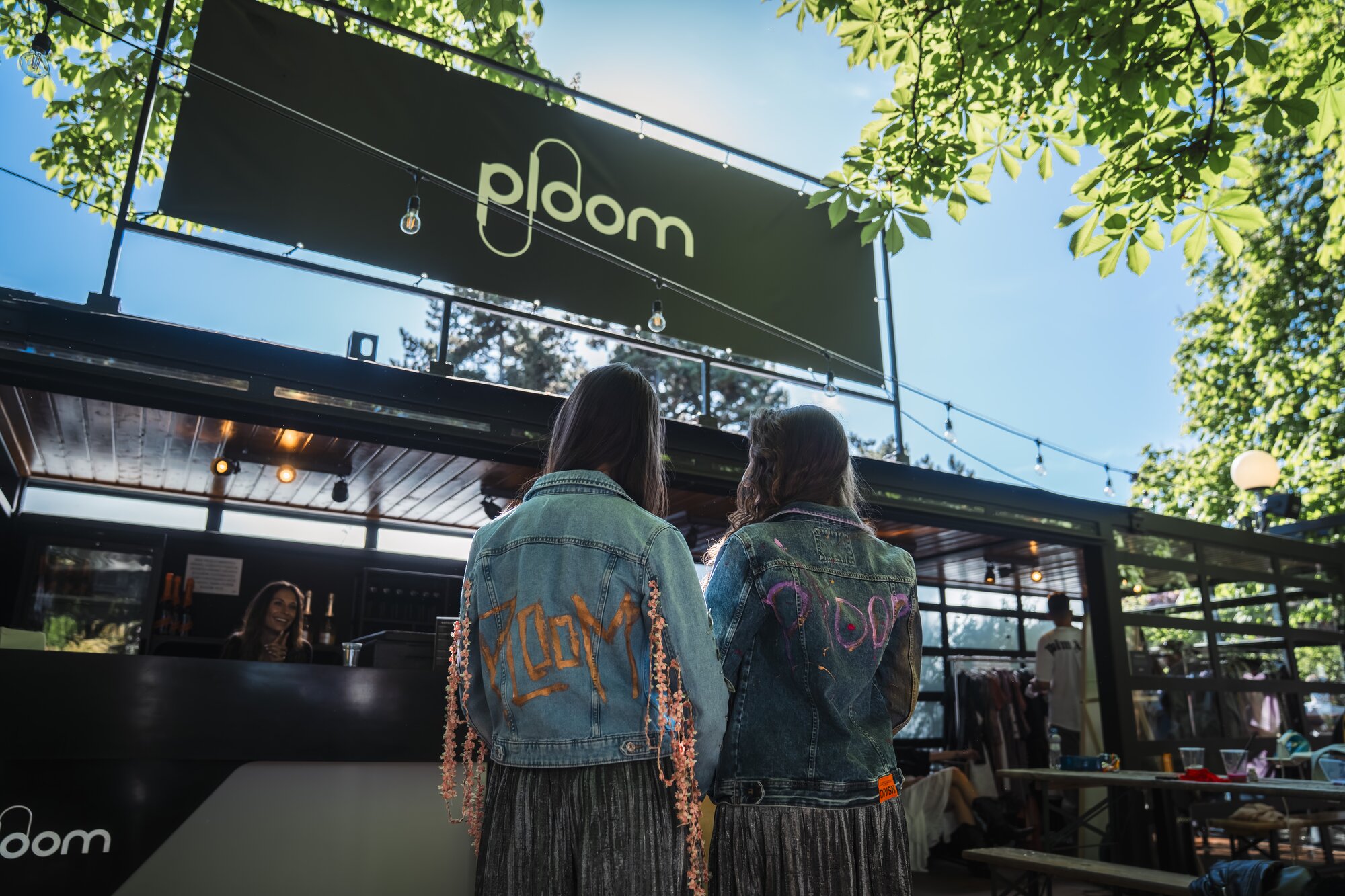 2 zariadenia Ploom AURA v čiernej farbe Jet Black na valentínskom pozadí so srdcom