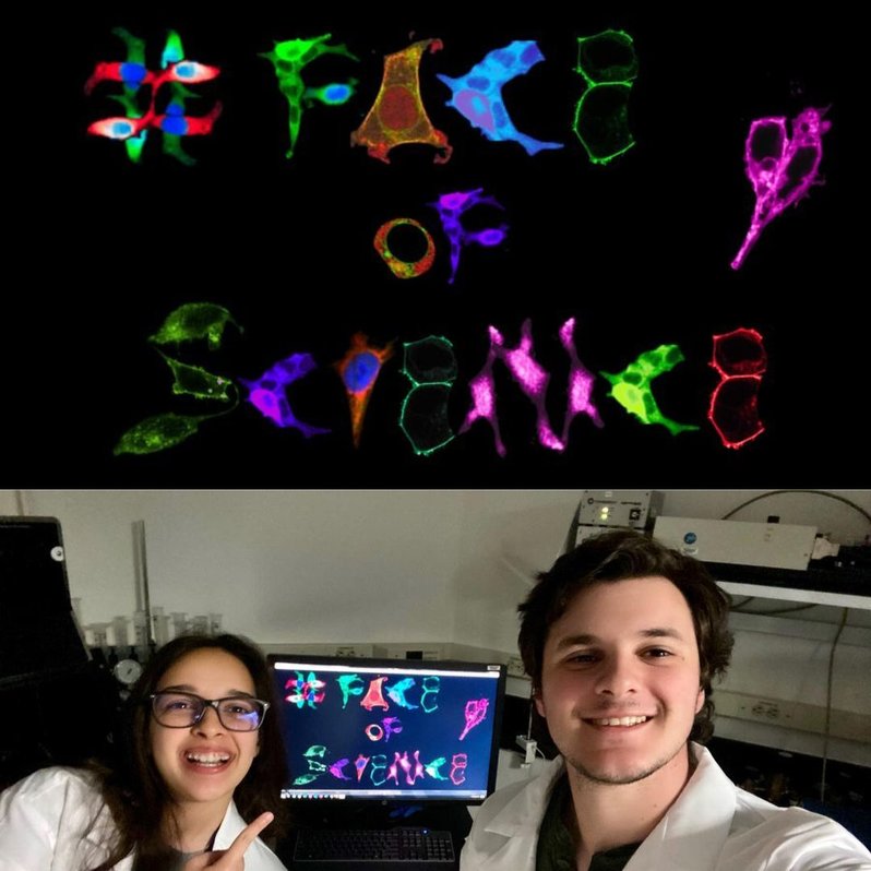 Two scientists stand in front of a monitor with an image they made: "#FaceOfScience" spelled out with "real cells we imaged for our experiments. We photoshopped and edited them to create words for our image!" 