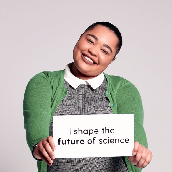 Jade Dodge smiling and  holding a sign that says "I shape the future of science